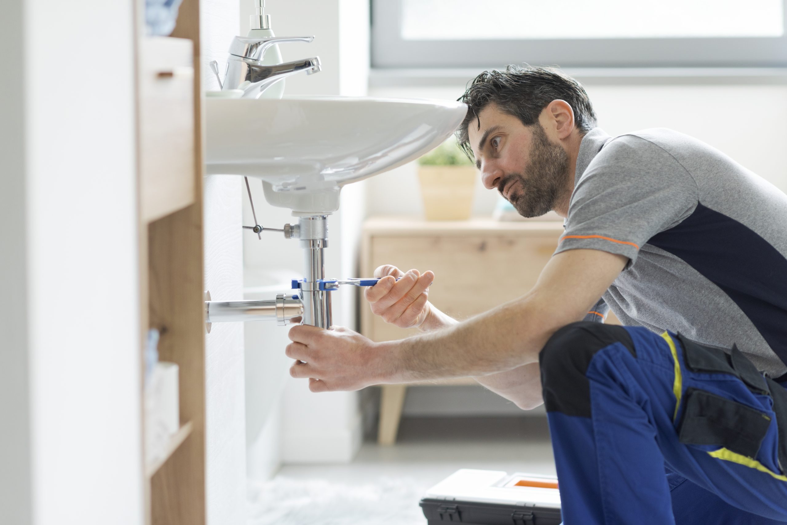 man working under sink